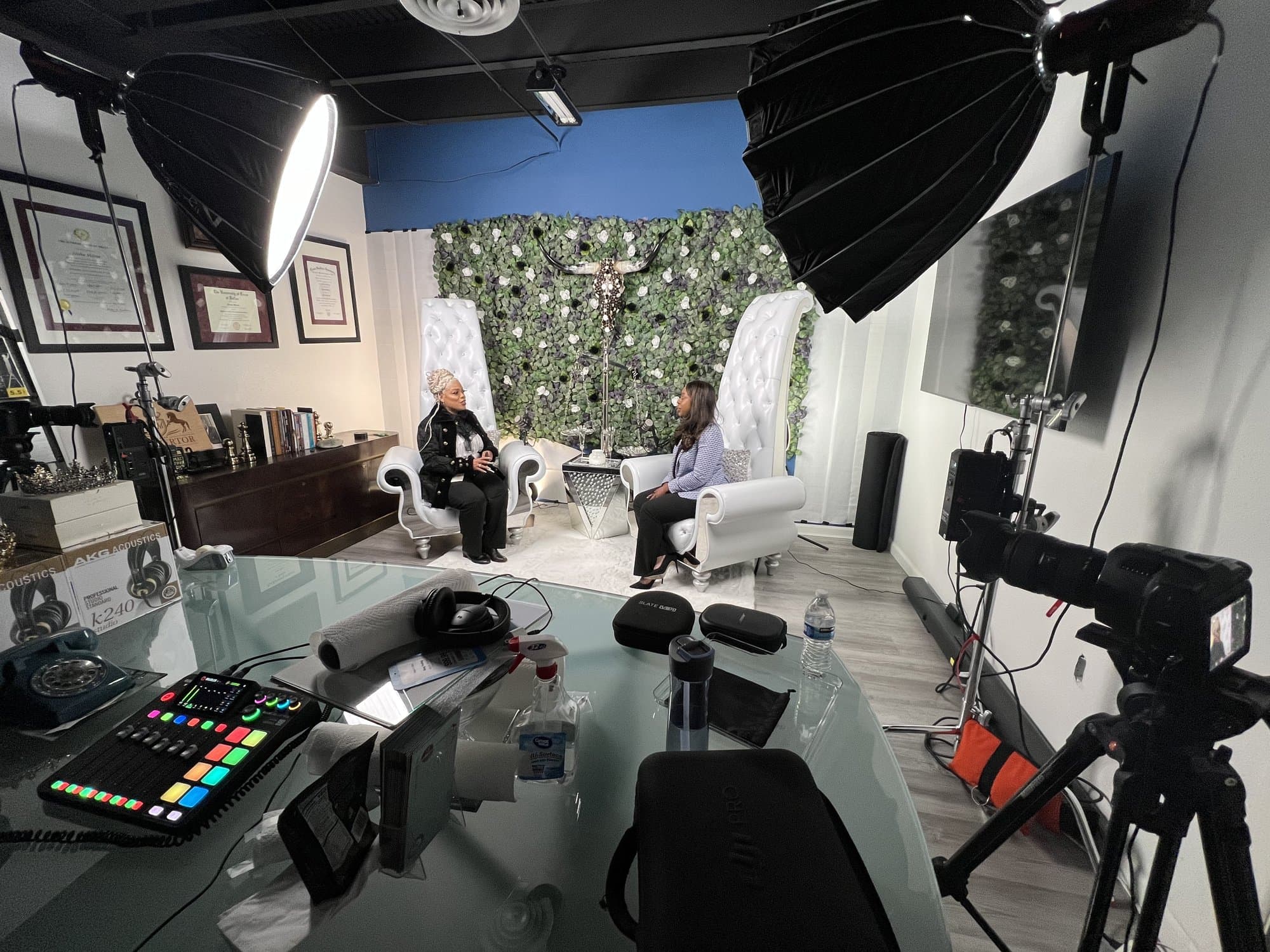 Wide behind-the-scenes view of the green-wall podcast set, with cameras, lights, and crew.